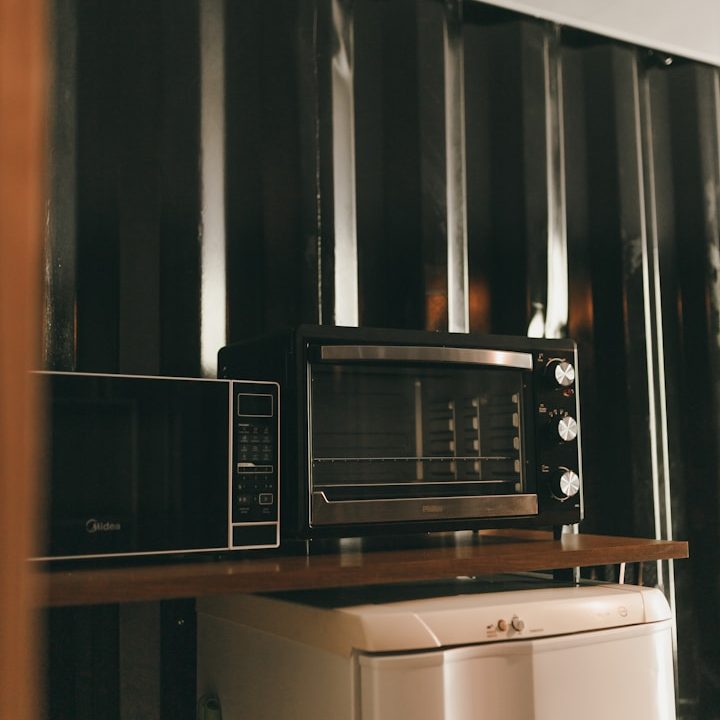 Schwarze Herdknöpfe mit silbernen Details auf einer modernen Kochstelle.