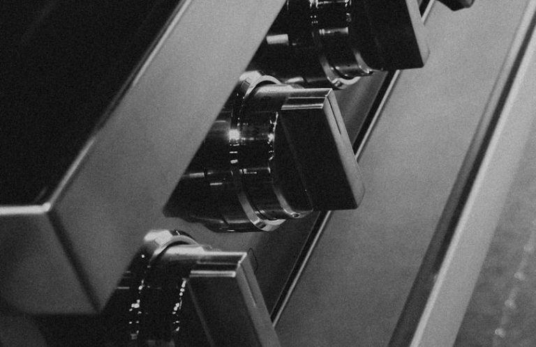 Nahaufnahmen von Drehreglern eines modernen Küchenherds in Schwarz.