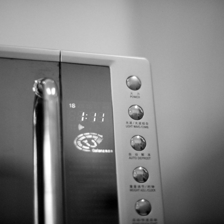 Ein moderner Mikrowellenherd mit einer Bedientafel und mehreren Tasten.