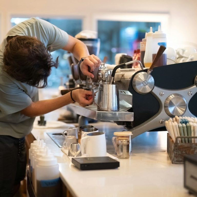 Barista bereitet Kaffee mit einer Espressomaschine in einem Café zu.