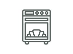 Ein Ofen mit geöffnetem Fach, in dem Croissants gebacken werden.