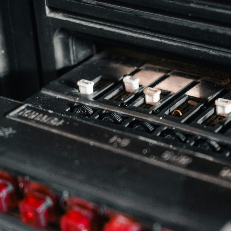 Detailaufnahme eines schwarzen Elektrogrills mit Schaltern und roten Lichtern.